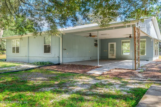 a view of a house with a yard and tree s