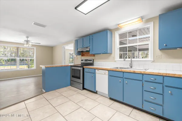 a kitchen with stainless steel appliances kitchen island granite countertop a stove a sink a refrigerator and cabinets