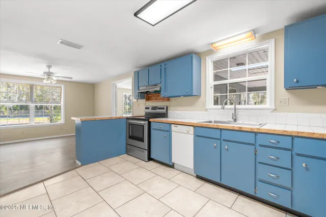 a kitchen with stainless steel appliances kitchen island granite countertop a stove a sink a refrigerator and cabinets