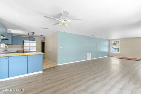 a view of an empty room with window and wooden floor