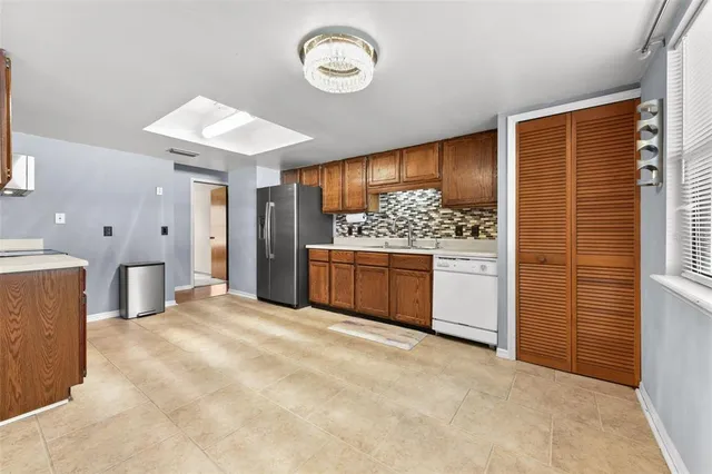 a view of a kitchen with stainless steel appliances wooden floor and a sink