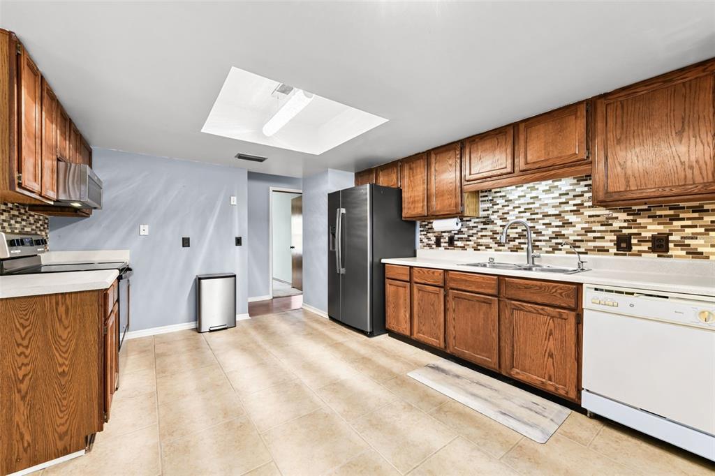 1580 East Normandy Boulevard Deltona, FL 32725 - Photo 12 of 46 a kitchen with stainless steel appliances granite countertop a stove a sink and a refrigerator