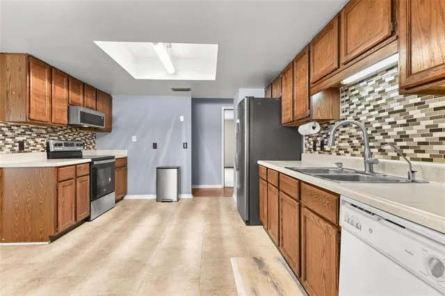 a kitchen with stainless steel appliances a sink stove and cabinets