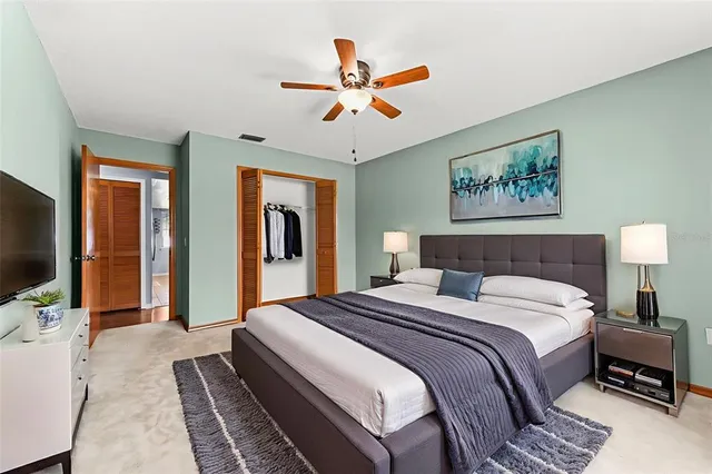 a spacious bedroom with a bed and a flat screen tv