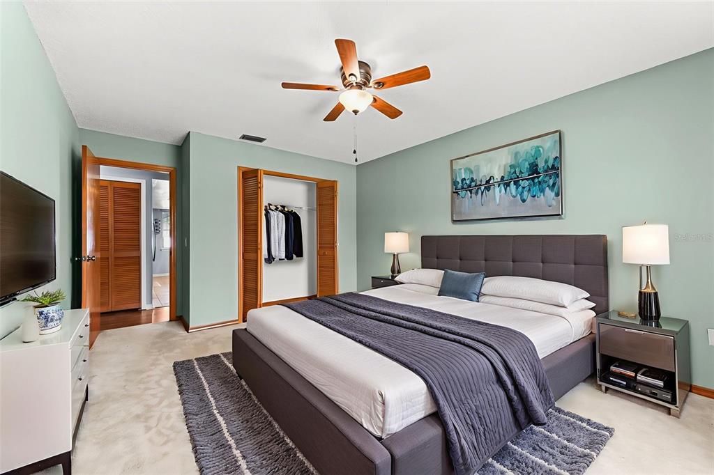 1580 East Normandy Boulevard Deltona, FL 32725 - Photo 29 of 46 a spacious bedroom with a bed and a flat screen tv