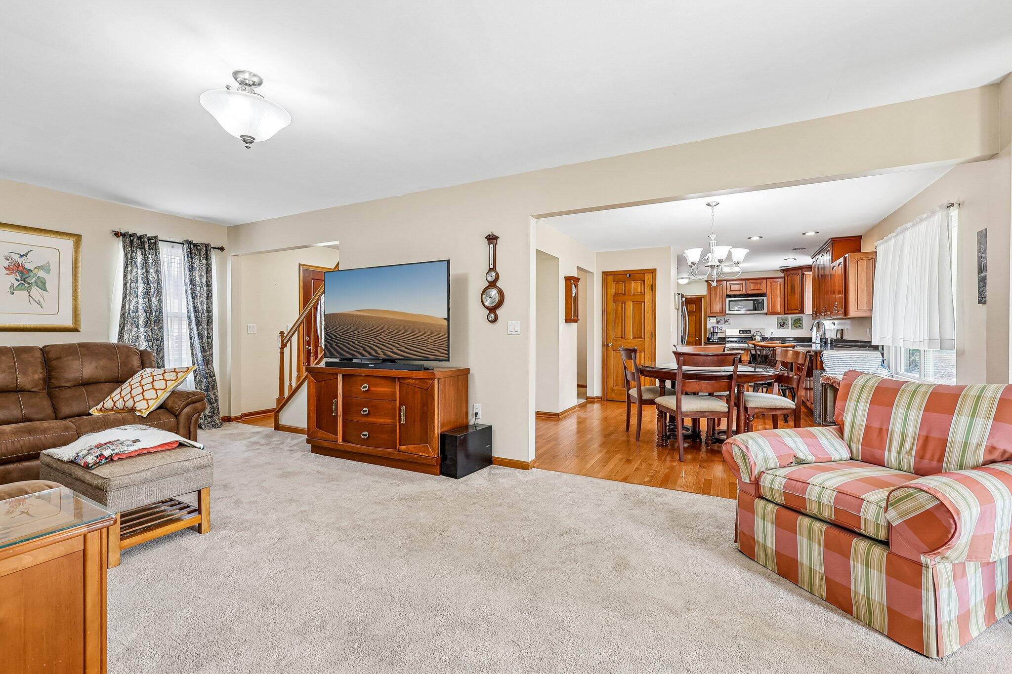 Open-concept living space with light-toned carpeting