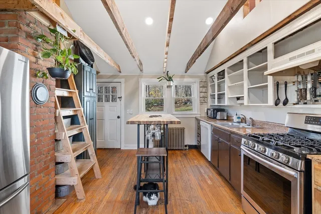 a kitchen with stainless steel appliances granite countertop lots of counter top space and wooden floors