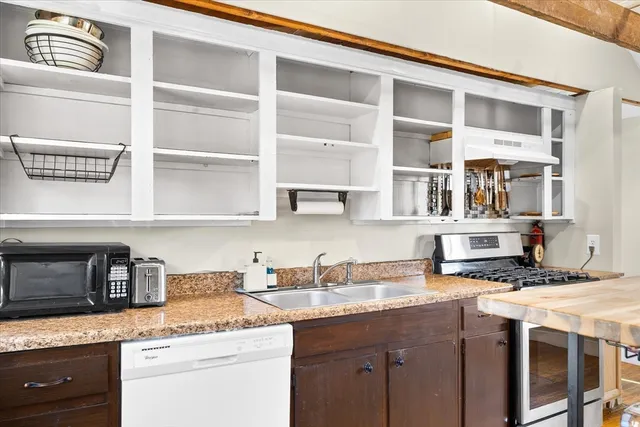 a kitchen with stainless steel appliances granite countertop a sink and a stove
