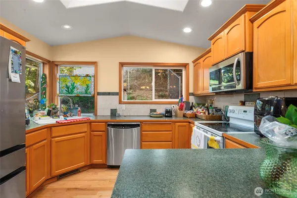 a kitchen with stainless steel appliances granite countertop sink stove top oven and cabinets