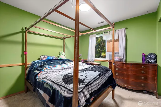 a bed sitting in a bedroom next to a window