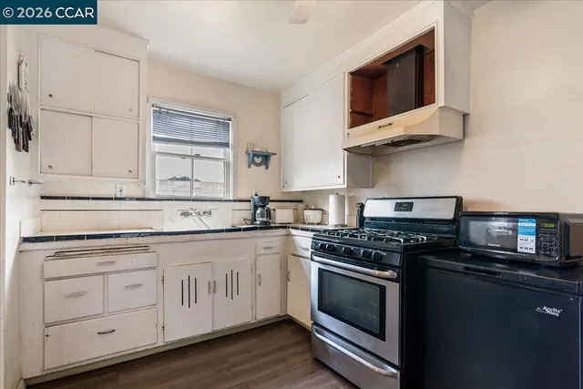 a kitchen with stainless steel appliances granite countertop white cabinets a stove top oven and dishwasher