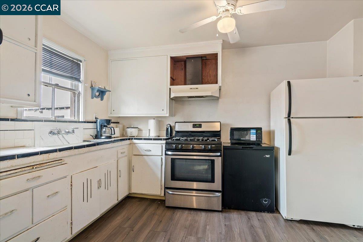 178 Army Street Pittsburg, CA 94565 - Photo 9 of 24 a kitchen with cabinets stainless steel appliances and wooden floor