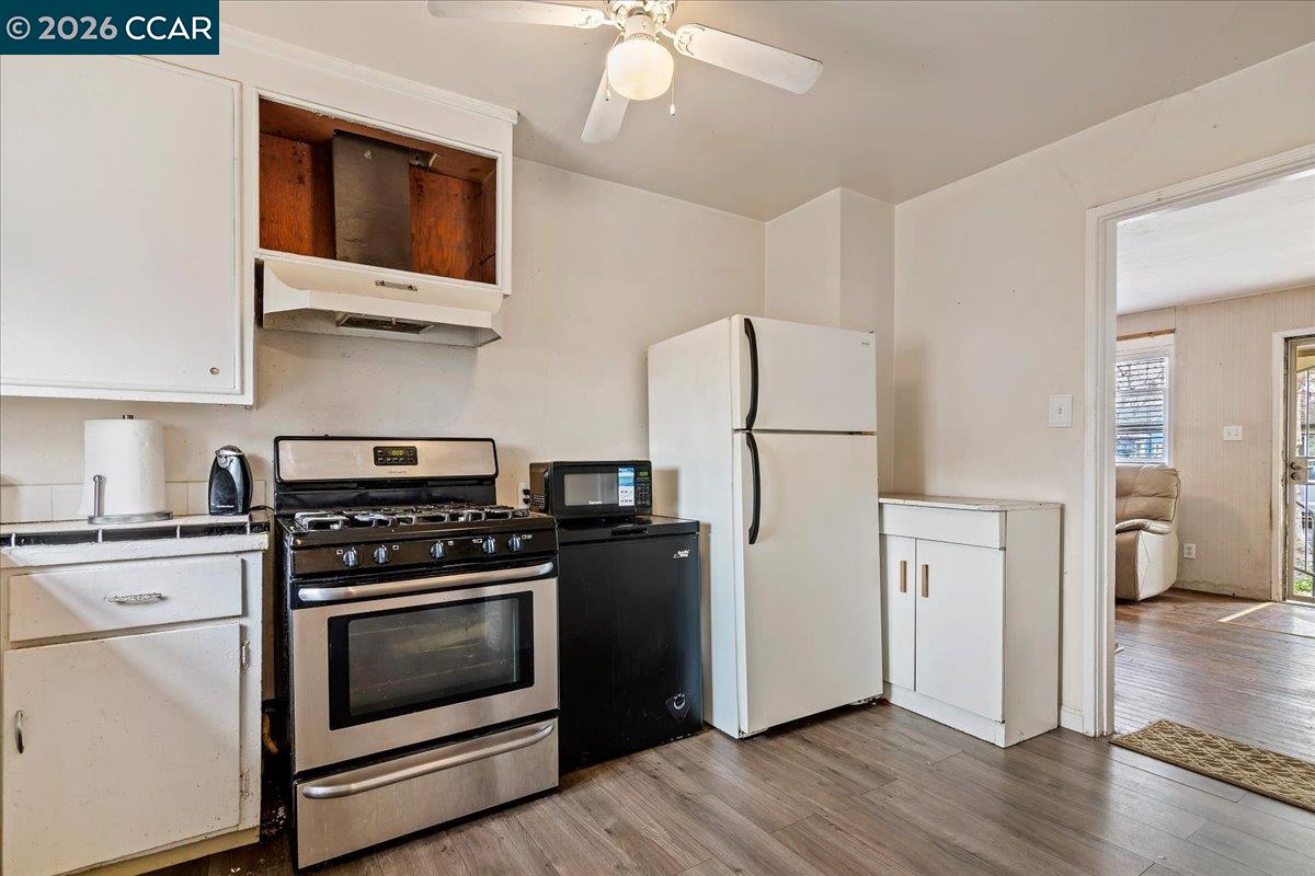 178 Army Street Pittsburg, CA 94565 - Photo 10 of 24 a kitchen with stainless steel appliances a refrigerator a stove and white cabinets