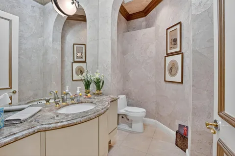 a bathroom with a granite countertop sink mirror vanity and toilet