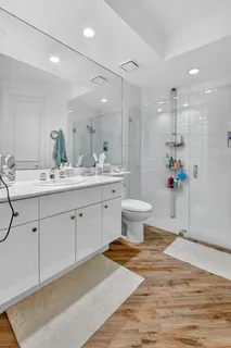 a spacious bathroom with a sink toilet a mirror and shower