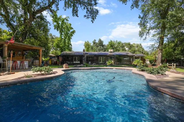 a view of house with outdoor space and swimming pool