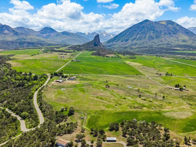 a view of a big yard with table and chairs and wooden fence