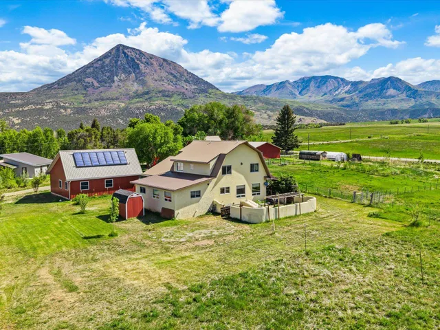 a aerial view of a house with yard and green space