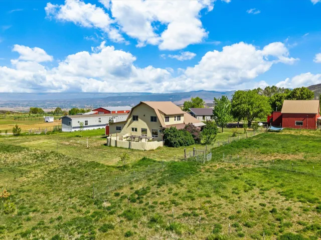 a view of a house with a big yard and large trees