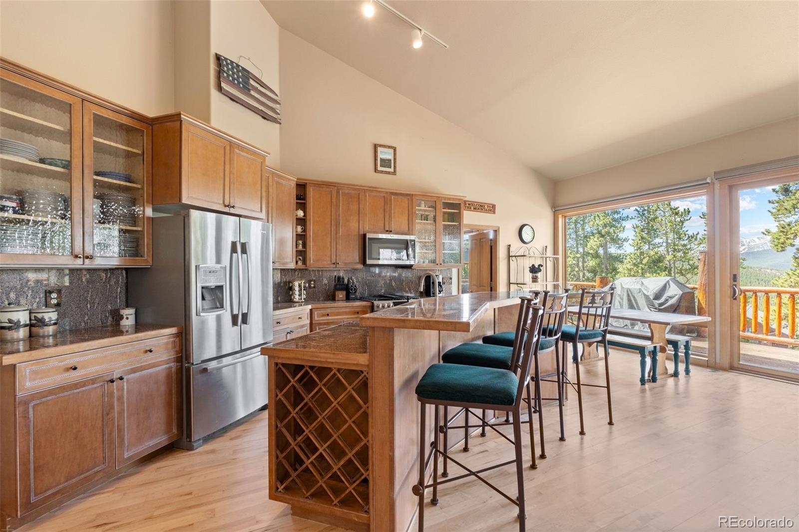 92 Emmett Lode Road, Unit B Breckenridge, CO 80424 - Photo 18 of 50 a kitchen with stainless steel appliances kitchen island granite countertop a table chairs and a refrigerator