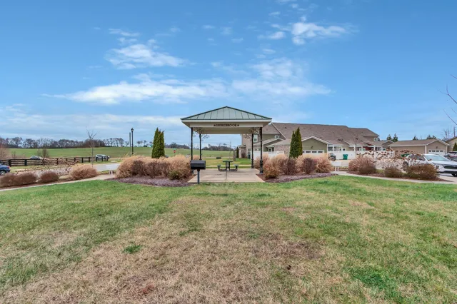 a backyard of a house with table and chairs