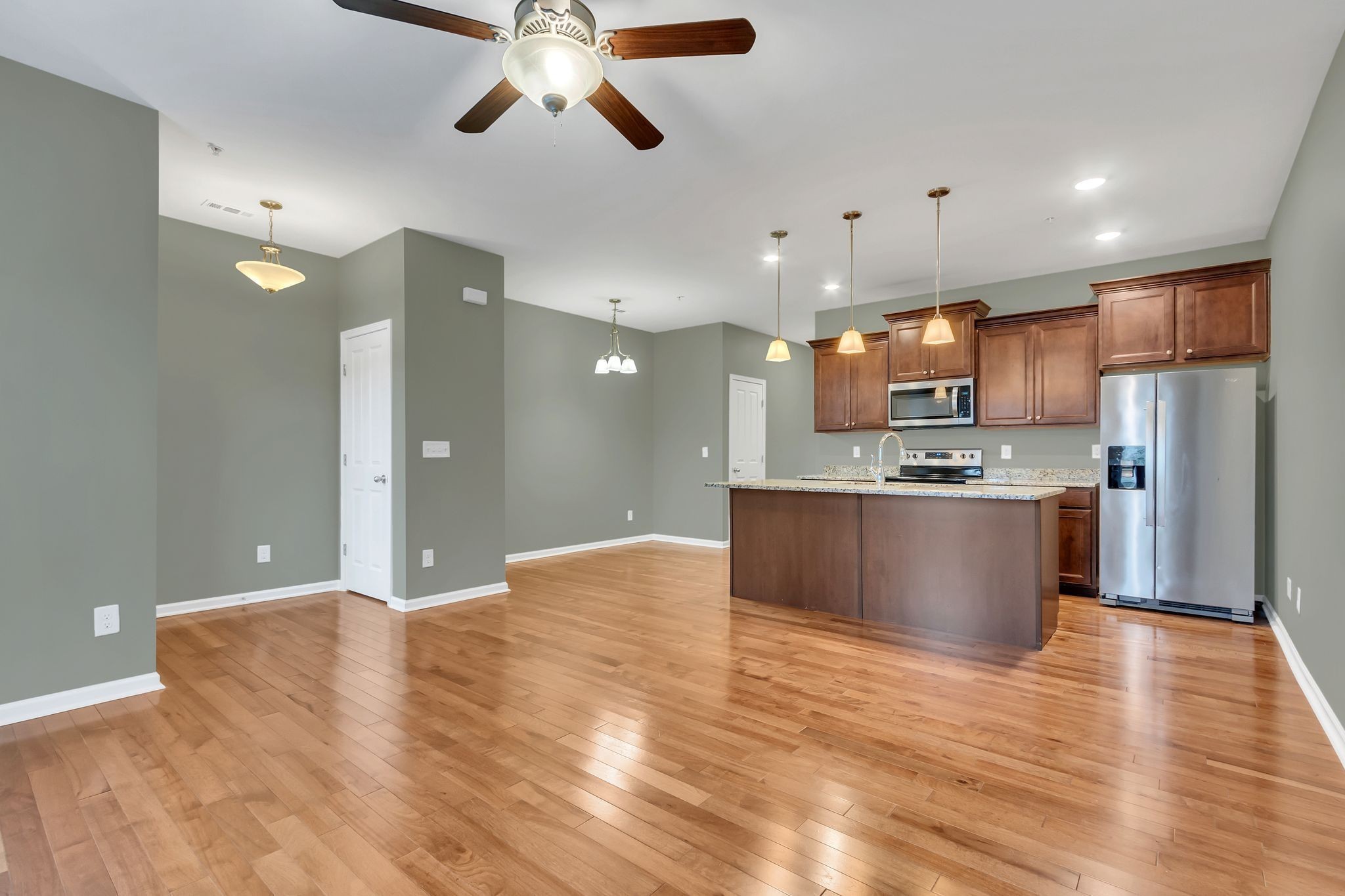 305 Dursley Lane Spring Hill, TN 37174 - Photo 7 of 25 a large kitchen with stainless steel appliances kitchen island a refrigerator sink a stove and a oven with wooden floor