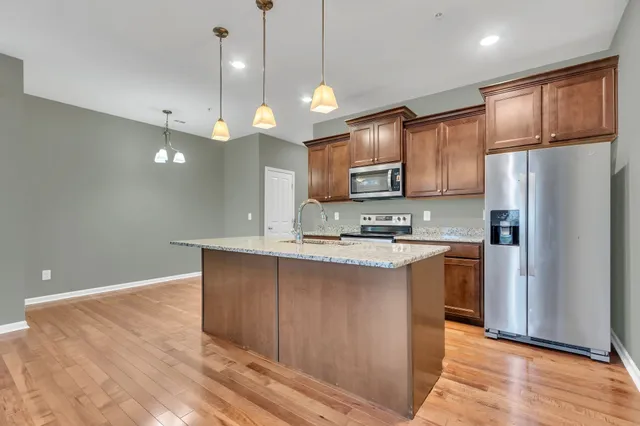 a large kitchen with kitchen island a sink stainless steel appliances and cabinets