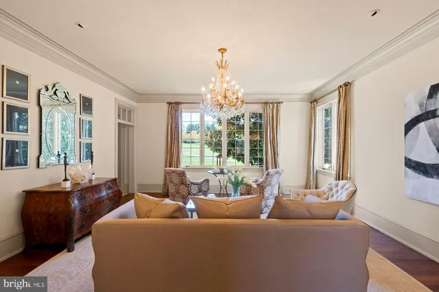a dining room with furniture a chandelier and wooden floor