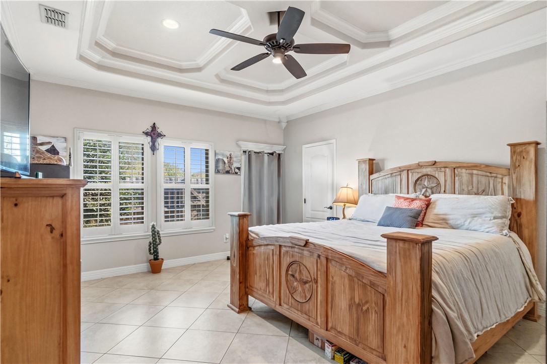 6934 Wooldridge Road, Unit K Corpus Christi, TX 78414 - Photo 12 of 20 a bedroom with a bed a window and a chandelier