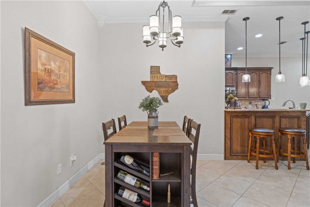 6934 Wooldridge Road, Unit K Corpus Christi, TX 78414 - Photo 4 of 20 a dining room with furniture and chandelier