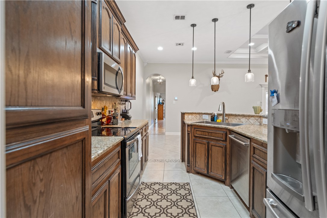 6934 Wooldridge Road, Unit K Corpus Christi, TX 78414 - Photo 9 of 20 a kitchen with stainless steel appliances granite countertop a sink a stove and a refrigerator