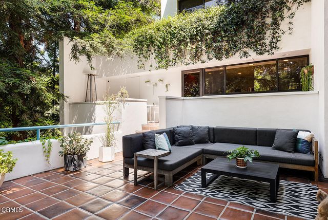 a balcony with wooden benches and a couch
