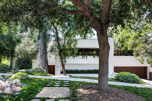 a front view of a house with a tree and a yard