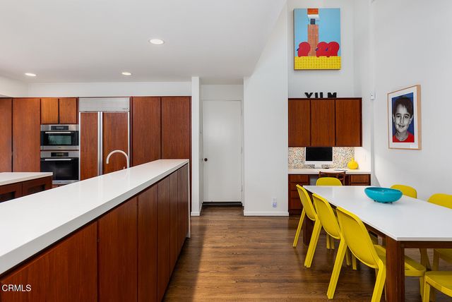 a kitchen with stainless steel appliances cabinets and wooden floor