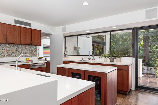 a kitchen with stainless steel appliances sink stove and large window