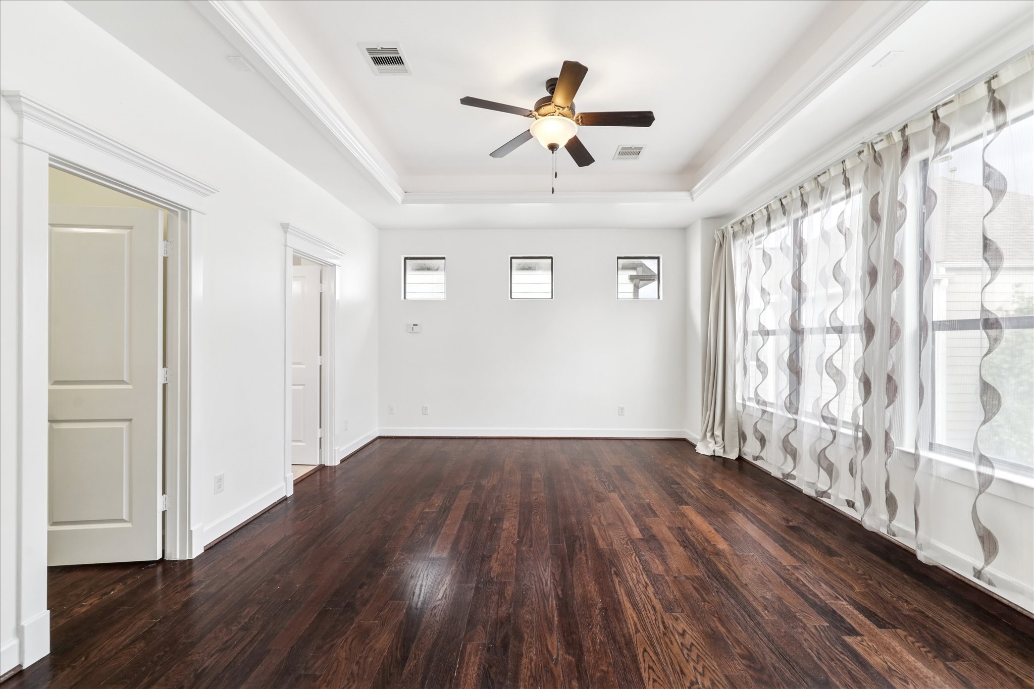 830 West 19th Street, Unit B Houston, TX 77008 - Photo 19 of 38 a view of a livingroom with wooden floor a ceiling fan and windows
