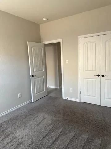 a view of a room with a ceiling fan and window