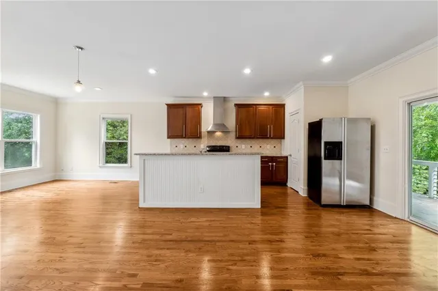 a view of kitchen with microwave a stove and wooden floor
