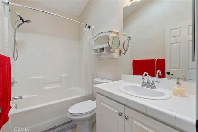 a bathroom with a granite countertop sink a toilet and shower