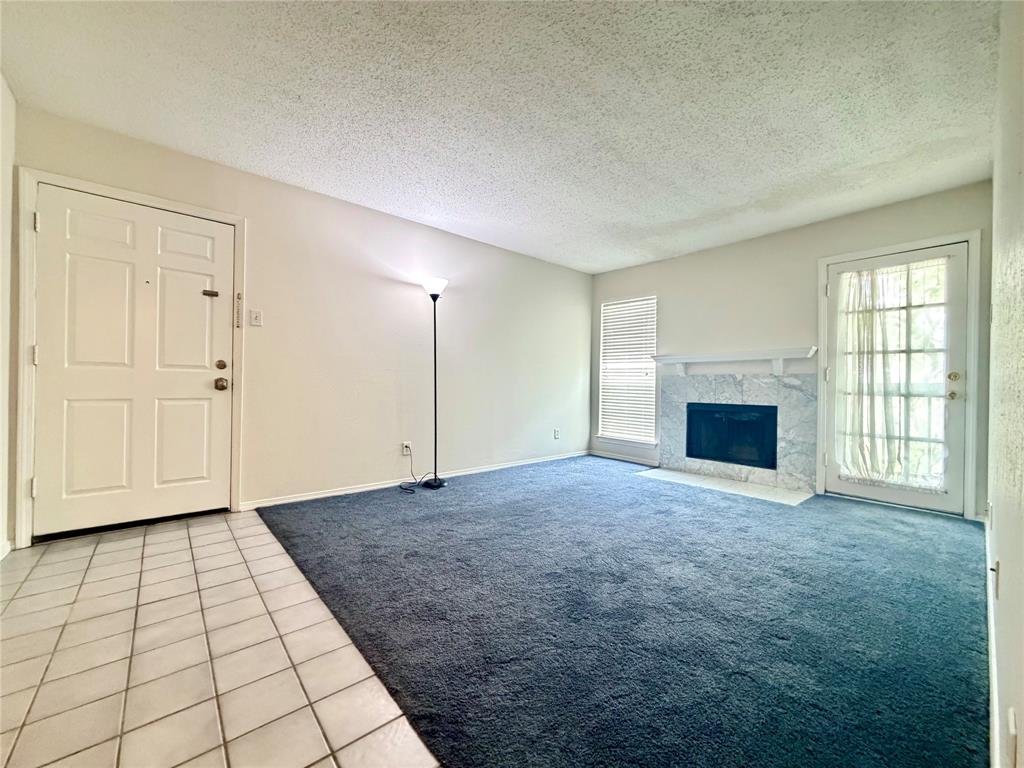 18333 Roehampton Drive, Unit 624 Dallas, TX 75252 - Photo 4 of 39 a view of an empty room with a fireplace and a window