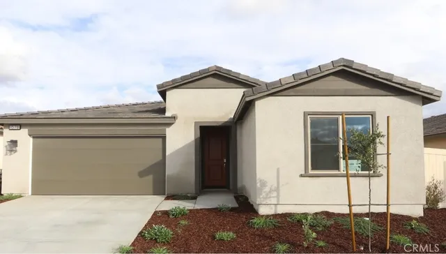a view of a house with a small yard and potted plants