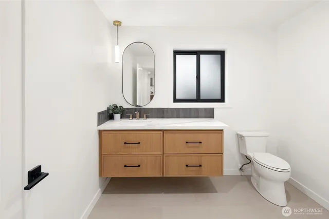 a bathroom with a toilet sink and mirror