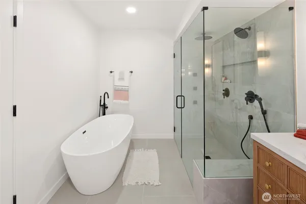 a bathroom with a tub sink shower and mirror
