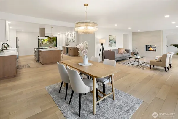 a view of a dining room and livingroom with furniture wooden floor a chandelier