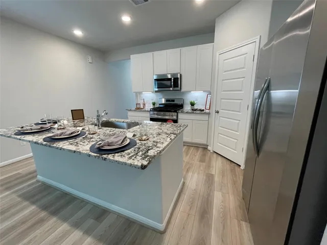 a kitchen with stainless steel appliances granite countertop a sink stove and refrigerator
