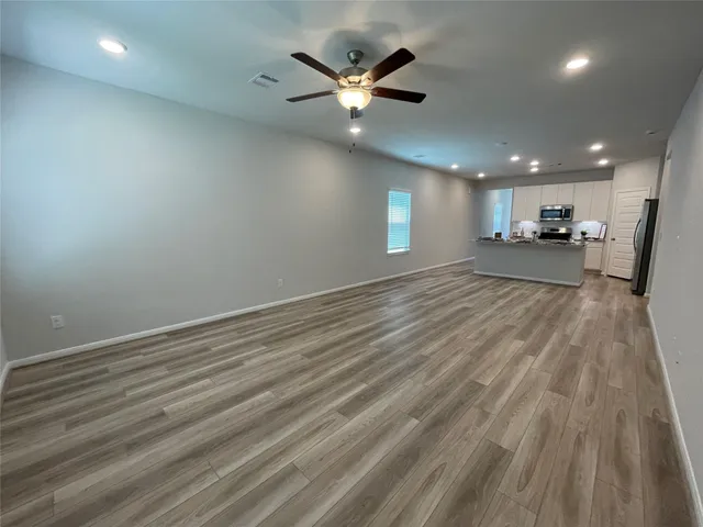 a view of a livingroom with a ceiling fan and wooden floor
