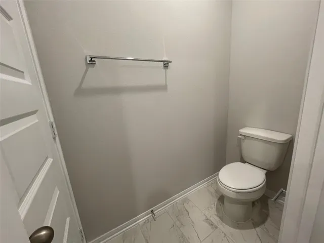 a white toilet sitting next to a shower