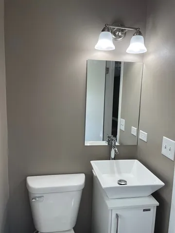 a bathroom with a toilet sink and mirror