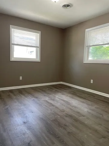 a view of a room with wooden floor and windows
