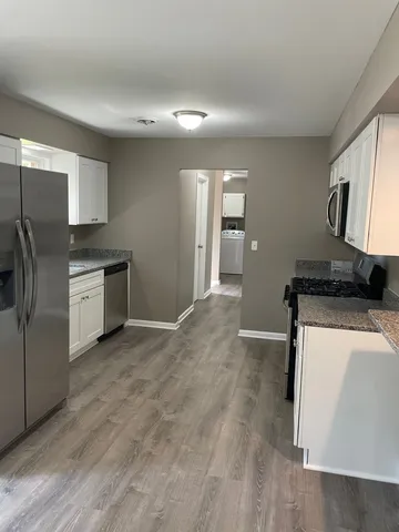 a kitchen with stainless steel appliances granite countertop a refrigerator and a stove
